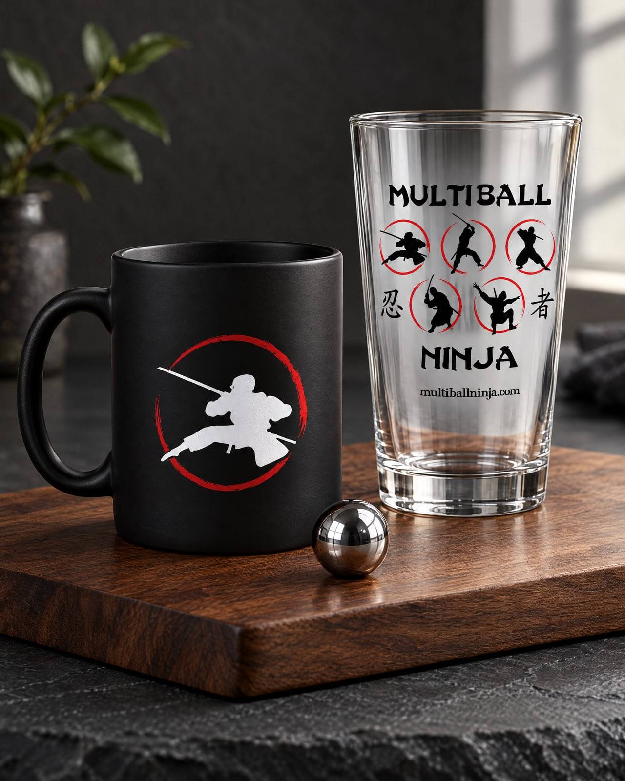 Concept mockup of a black mug with a ninja in a red ring and a pint glass printed with the full Multiball Ninja logo, on walnut